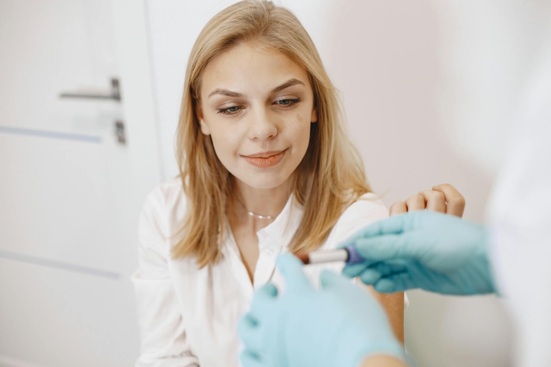 Pobieranie krwi u blond kobiety w gabinecie do badań laboratoryjnych